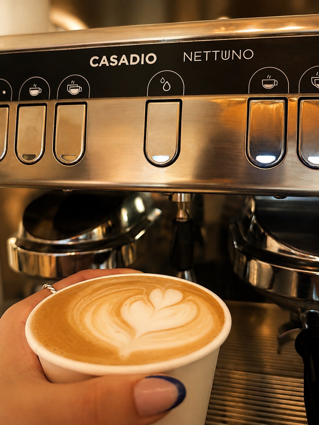 Latte de Caracola Coffee Bar frente a la máquina de espresso